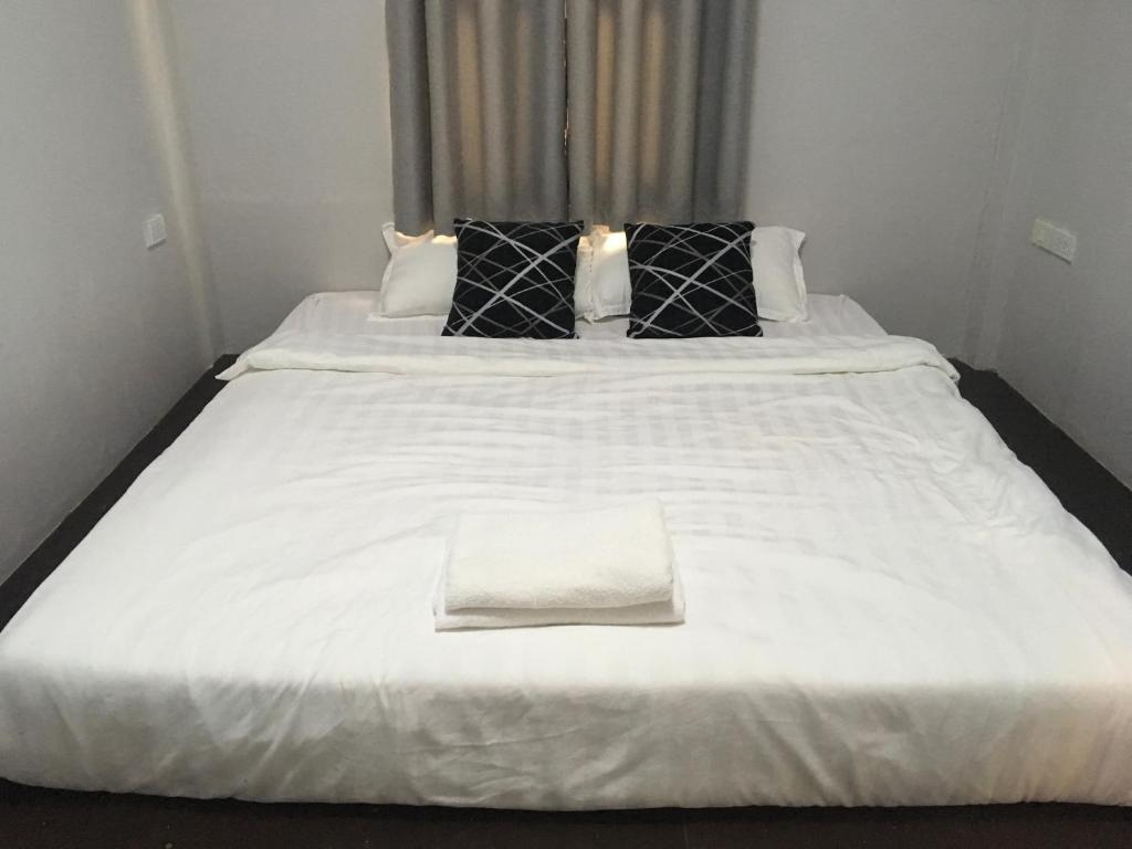 ein großes weißes Bett mit einem weißen Handtuch drauf in der Unterkunft Mekong Riverside in Vientiane