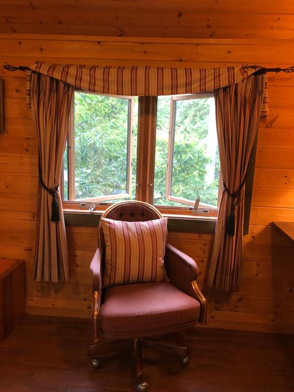 una silla en una habitación con ventana en YU・CABIN en Inawashiro