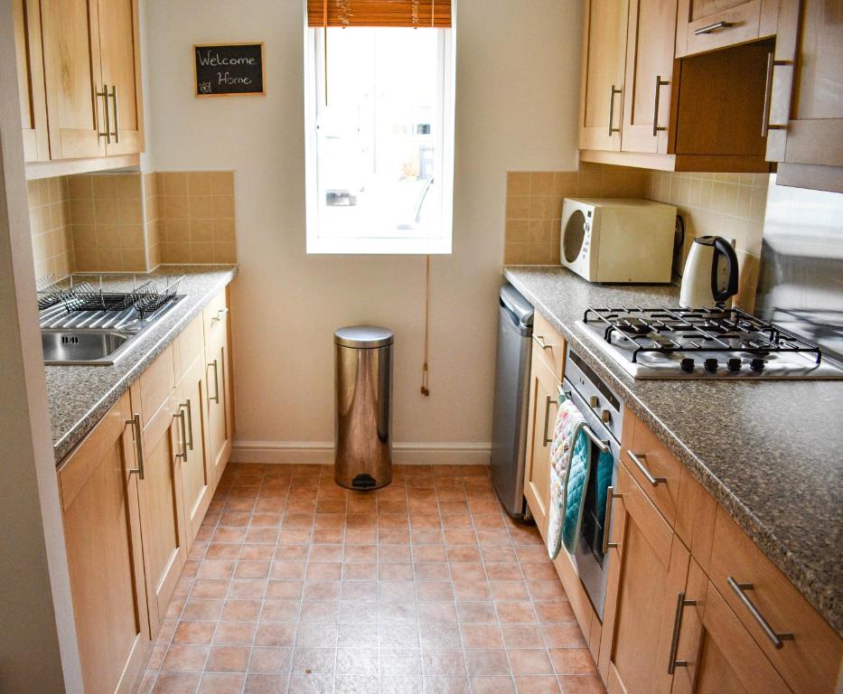 a kitchen with a sink and a stove top oven at Welcome Home in Royston