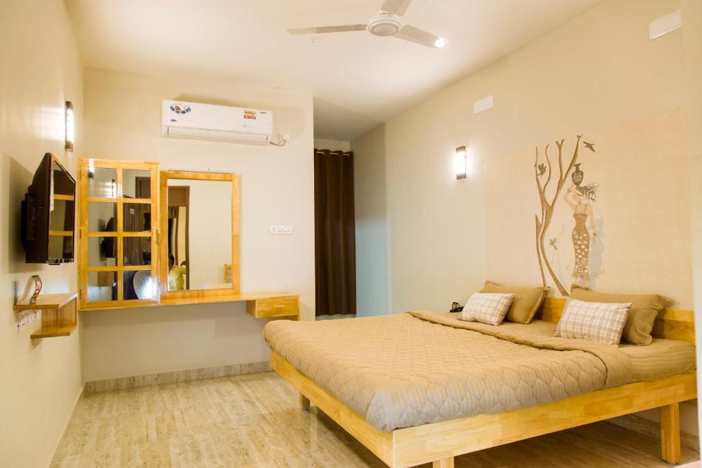 a bedroom with a bed and a mirror at Rathna Square in Pollāchi