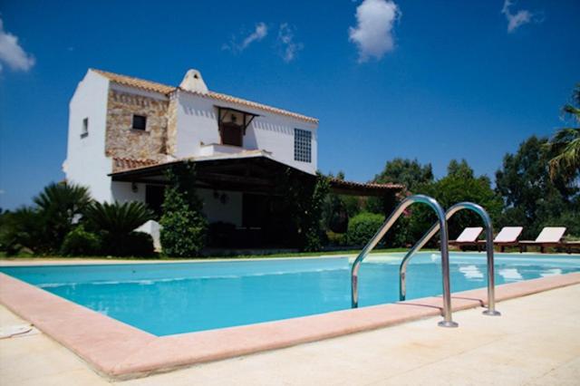 una casa con piscina frente a una casa en Villa Silvia Apartment, en Olmedo