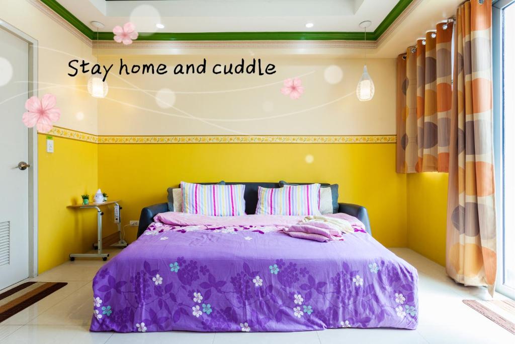 - une chambre dotée d'un lit violet, d'une maison et d'un coin repas dans l'établissement Condo Unit Near Terminal 3, à Manille