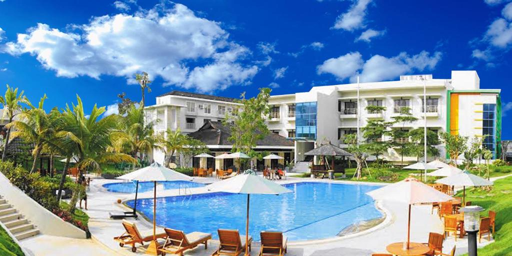 una piscina con sillas y sombrillas frente a un hotel en Samara Resort, en Batu