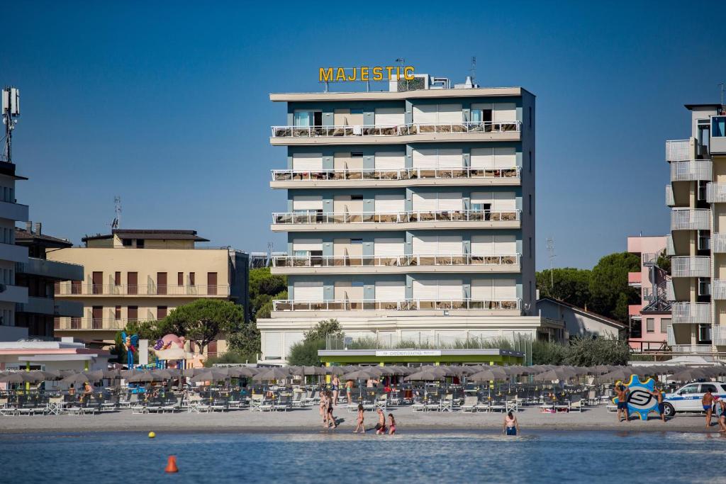 un hotel sulla spiaggia con persone sulla spiaggia di Hotel Majestic a Milano Marittima