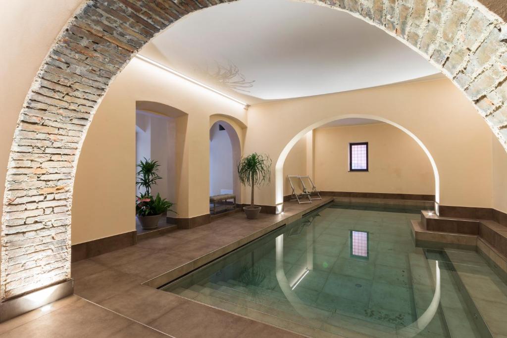 an indoor swimming pool with a brick wall and an archway at Agave in Città in Livorno