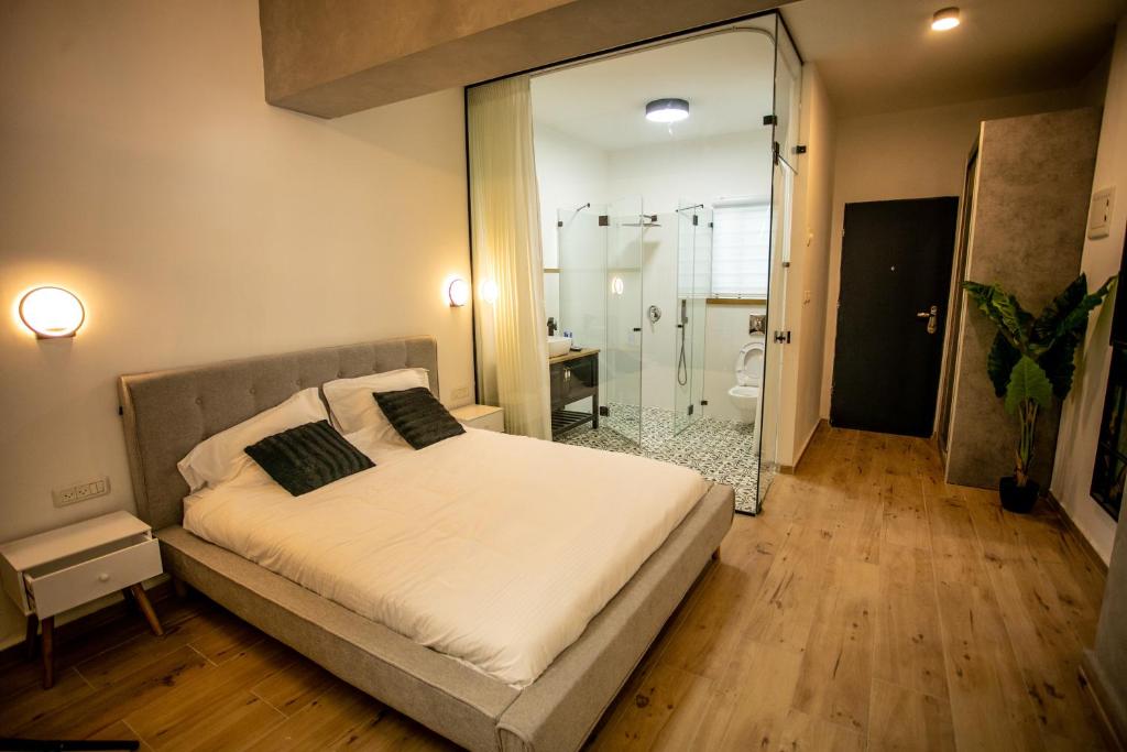 una camera con letto e un bagno con doccia di Eshel Mansion - Boutique Suites a Beer Sheva