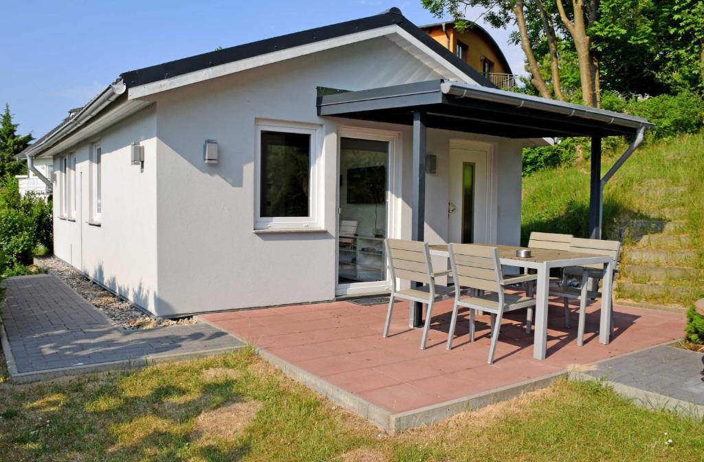 une maison avec une table et des chaises sur une terrasse dans l'établissement Ferienhaus in Goehren, à Göhren