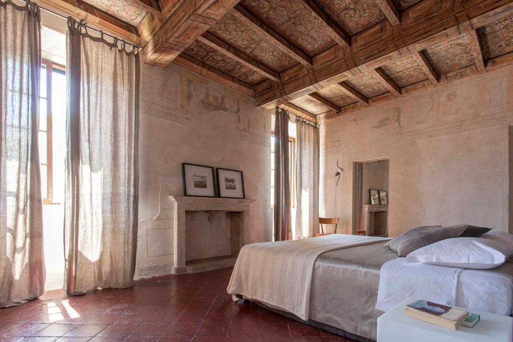 a bedroom with a large bed and a fireplace at Corte Mainolda in Castellucchio