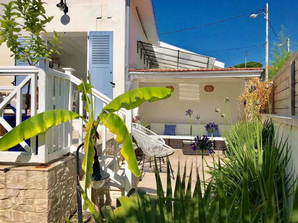 une terrasse avec une chaise et des plantes devant une maison dans l'établissement Villa LE TROIS MÂTS, à Arcachon