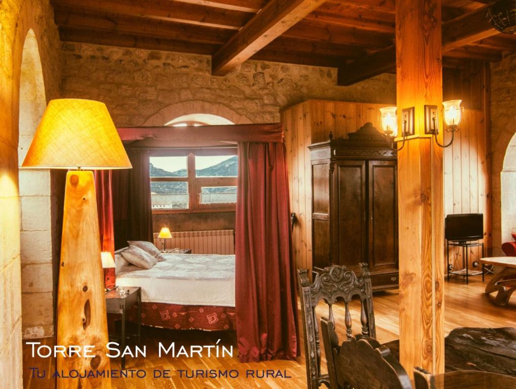 a bedroom with a bed and a table and a lamp at Torre San Martín in Quintana de Valdivielso