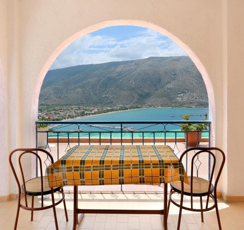 einen Tisch und Stühle auf einem Balkon mit Meerblick in der Unterkunft Panorama Plataria Ionio Studios&Apartments in Plataria