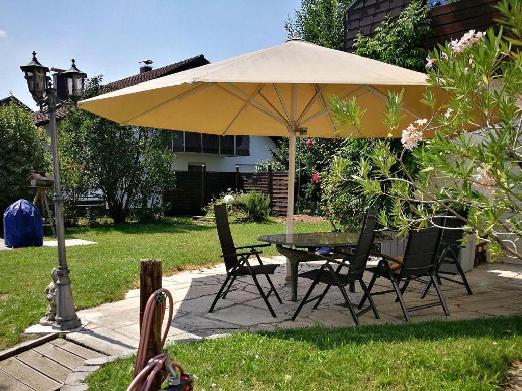 una mesa y sillas bajo una sombrilla en un patio en Apartment Muggensturm am Badesee, en Muggensturm
