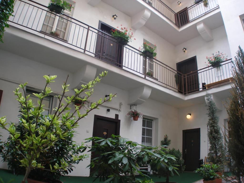 a large white building with balconies and plants at Mila Apartments in Prague