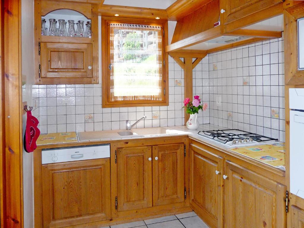 a kitchen with wooden cabinets and a sink and a stove at A detached chalet for 6 people with views of Veysonnaz in Le Villard