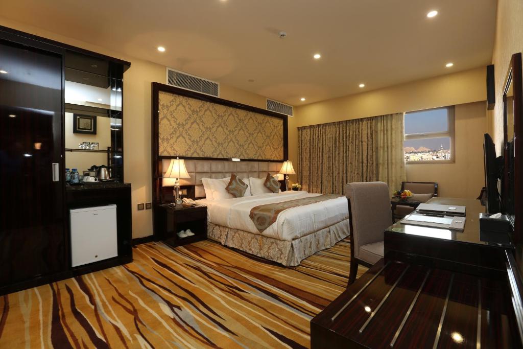Duży pokój hotelowy z łóżkiem i biurkiem w obiekcie Al Muhaidb Residence Al Ahsa w mieście Al Ahsa