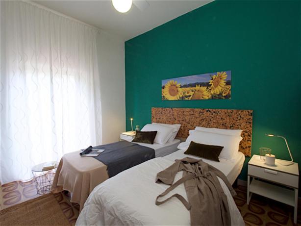 1 dormitorio con 2 camas y pared verde en Il bracconiere en Fonteblanda