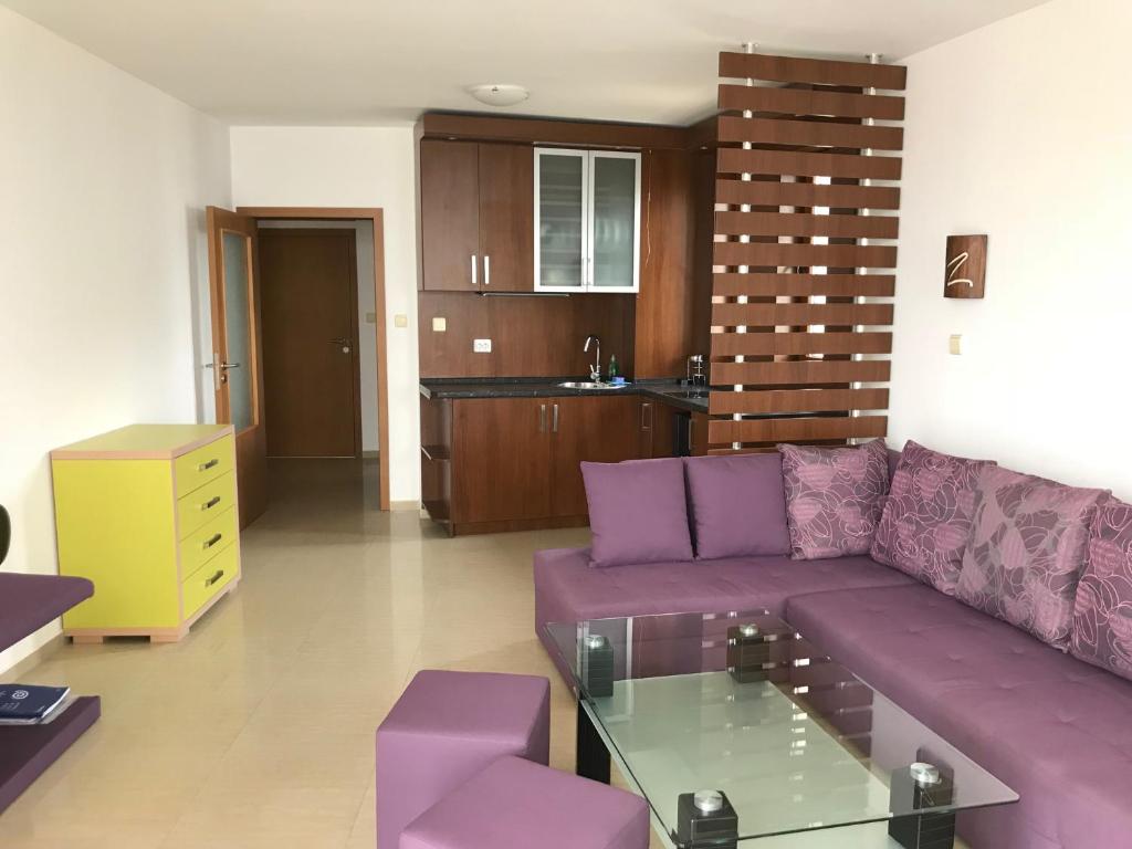 ソゾポルにあるApartment Slantseの紫色のソファ付きのリビングルーム、キッチンが備わります。