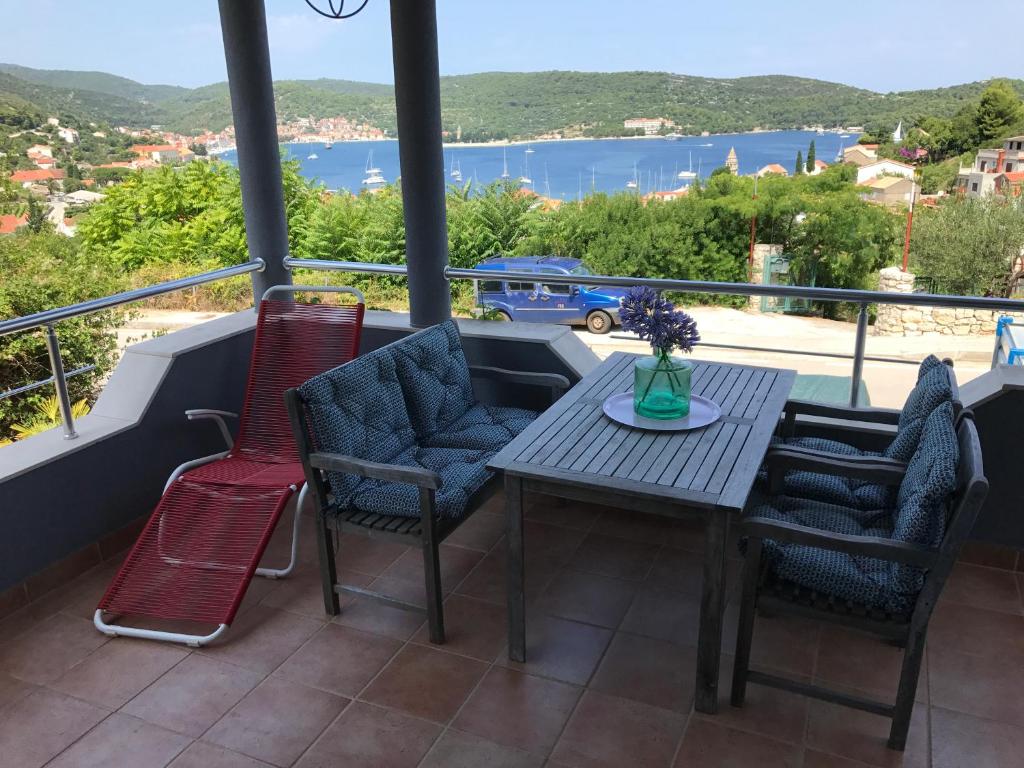 a table and chairs on a balcony with a view of the water at Vila Sunce Vis in Vis