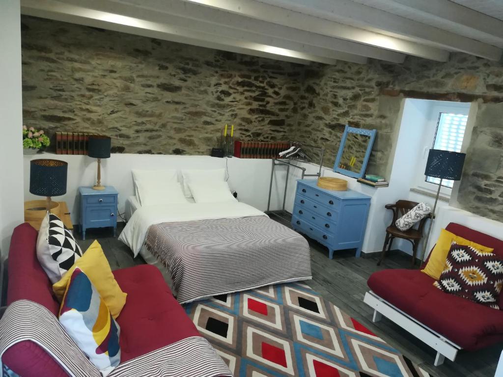 a bedroom with two beds and a stone wall at A Tasca in Vila Real