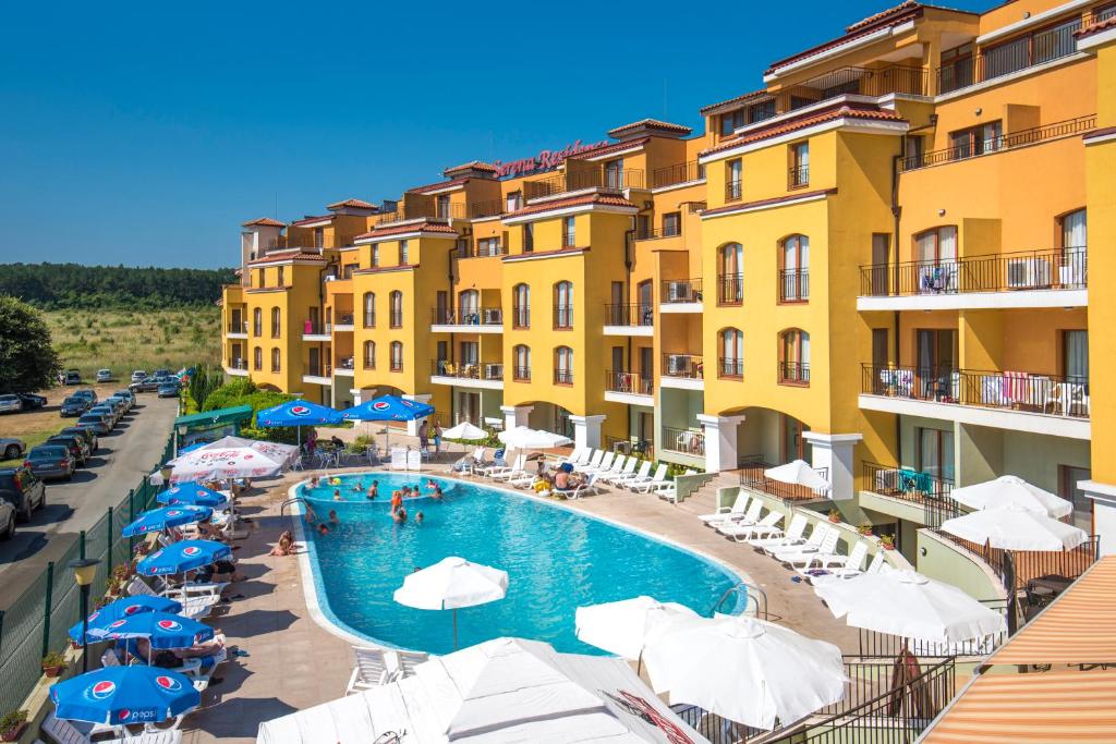 ソゾポルにあるSerena Residence Aparthotel - All Inclusiveのプールとパラソル付きのホテルの景色を望めます。