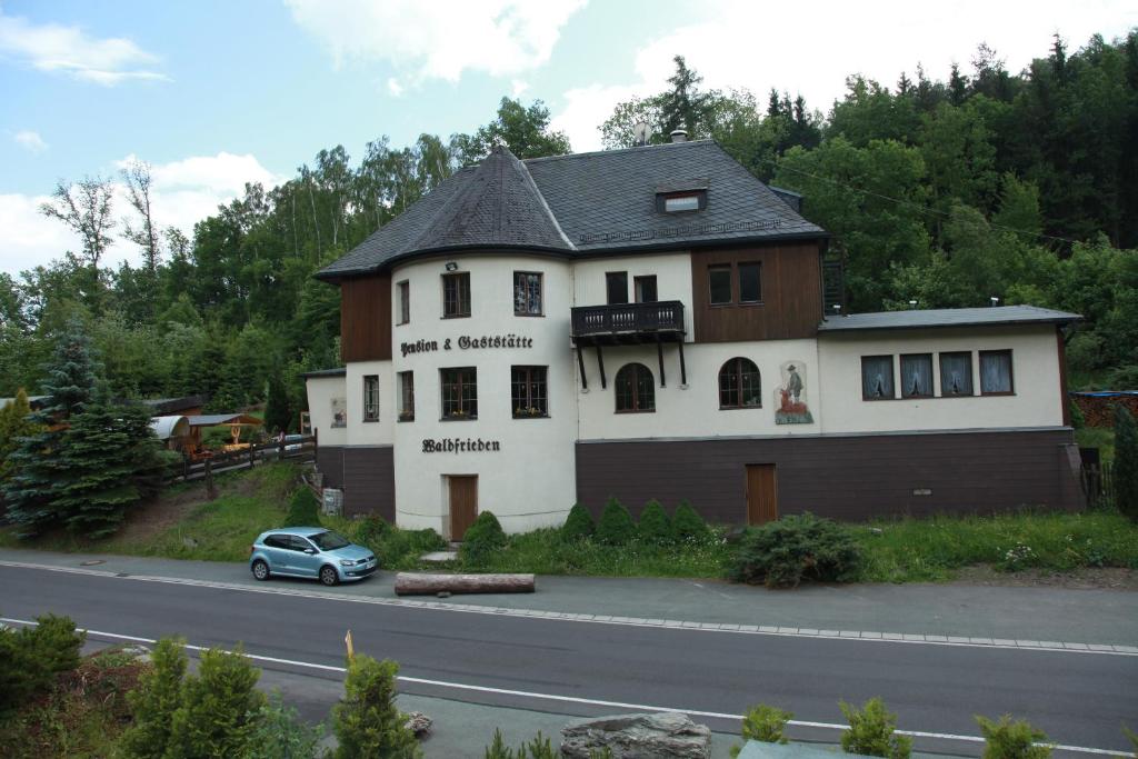una casa con un coche aparcado delante de ella en Hotel Waldfrieden, en Elsterberg