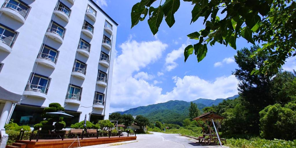 Blick auf ein Hotel mit Bergen im Hintergrund in der Unterkunft Namwon Hotel in Namwon