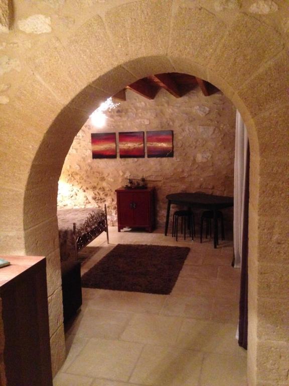 un arco che conduce a una sala da pranzo con tavolo di Jim cosy & spa a Saint-Hilaire-dʼOzilhan