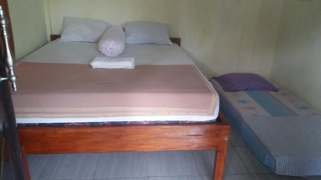 a small bedroom with two beds in it at Pedek Homestay in Praya