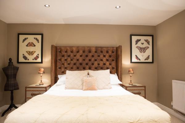 um quarto com uma grande cama branca e 2 candeeiros em Brewer's Cottage - Brosterfield Farm em Eyam