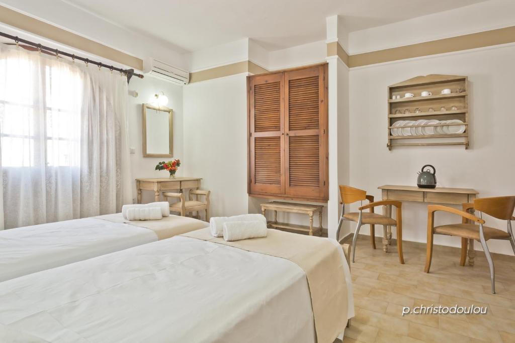 a hotel room with two beds and a table at Philoxenia Studios 2 in Karpathos