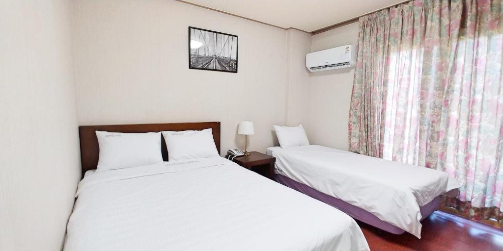 Postel nebo postele na pokoji v ubytování Namwon Hotel