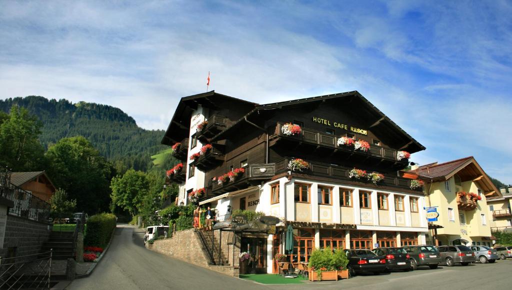 um edifício com flores ao lado de uma rua em Hotel Resch em Kitzbühel