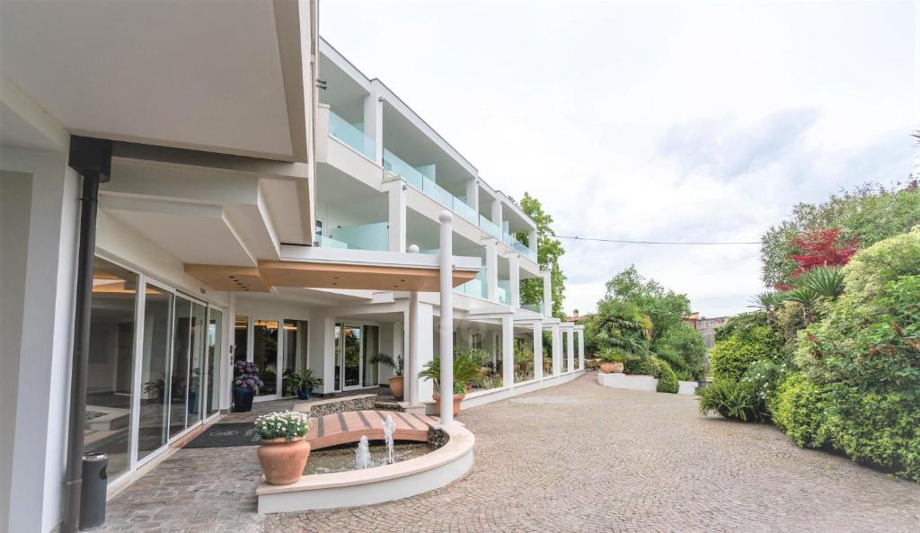 een gebouw met een bank ervoor bij Hotel Giulietta Romeo in Lazise