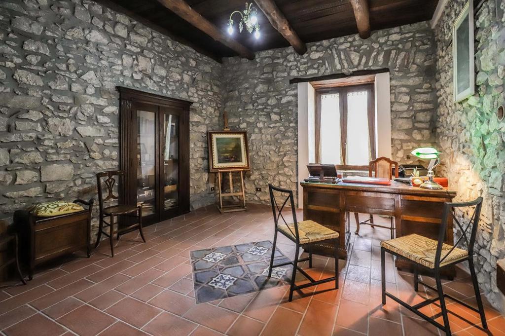a stone room with a wooden table and chairs at PietrAnticA in Trentinara