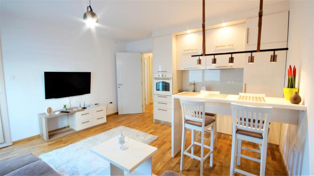 a kitchen and living room with a counter and a table at Apartment Lux Fontana in Budva