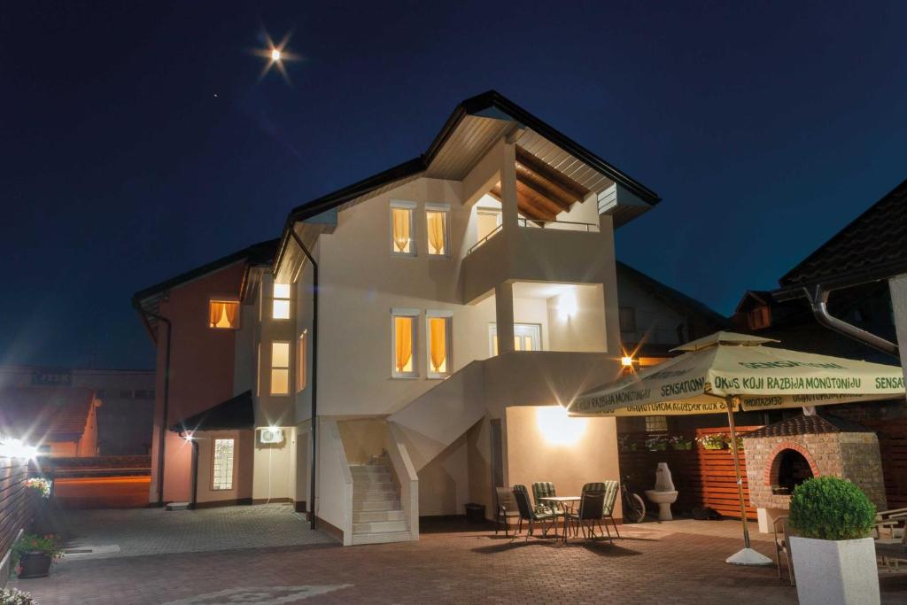 a white house with a staircase leading up to it at night at Villa Maja in Bihać