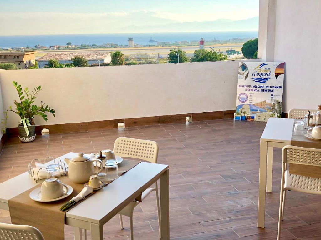 restauracja ze stołami i krzesłami oraz widokiem na pustynię w obiekcie Charm Airport w mieście Reggio di Calabria