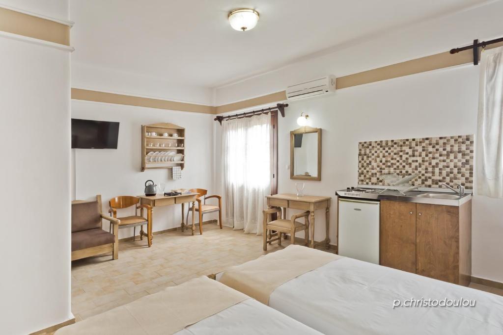 a bedroom with a bed and a kitchen and a table at Philoxenia Studios 3 in Karpathos Town