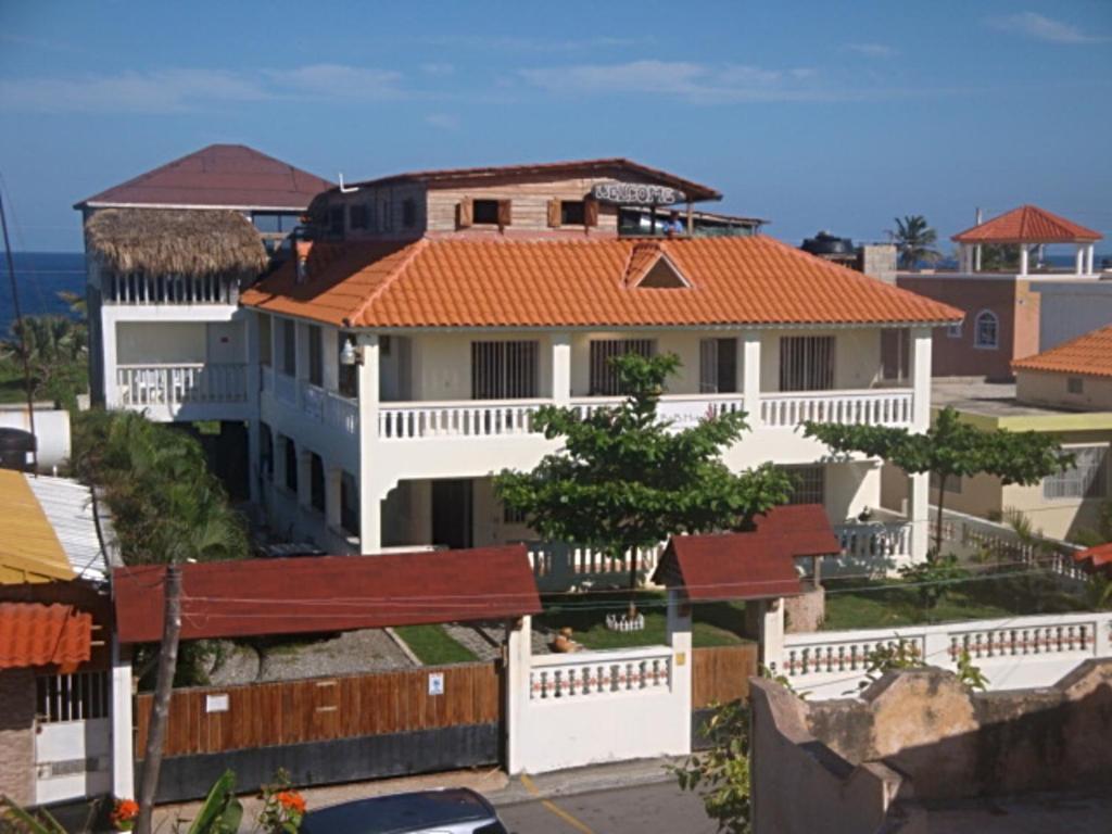 uma grande casa branca com um telhado laranja em El Malecon B&B Hotel em Cabrera