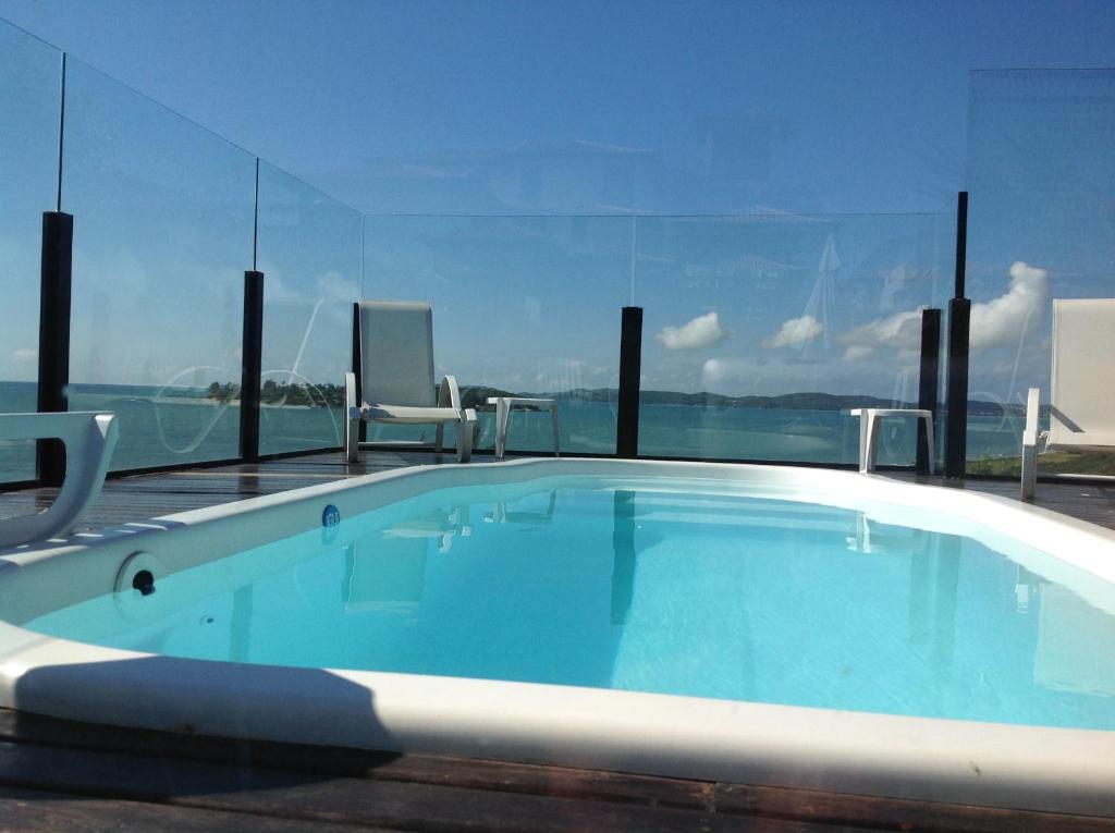 una piscina con sillas y vistas al océano en CASA 4QTOS PISCINA PRAIA, en Búzios