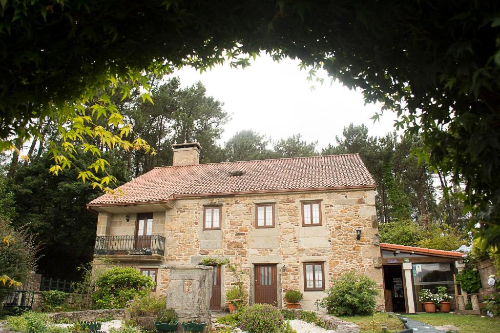 a stone house with a red roof at Casal de Cereixo in Tufiones