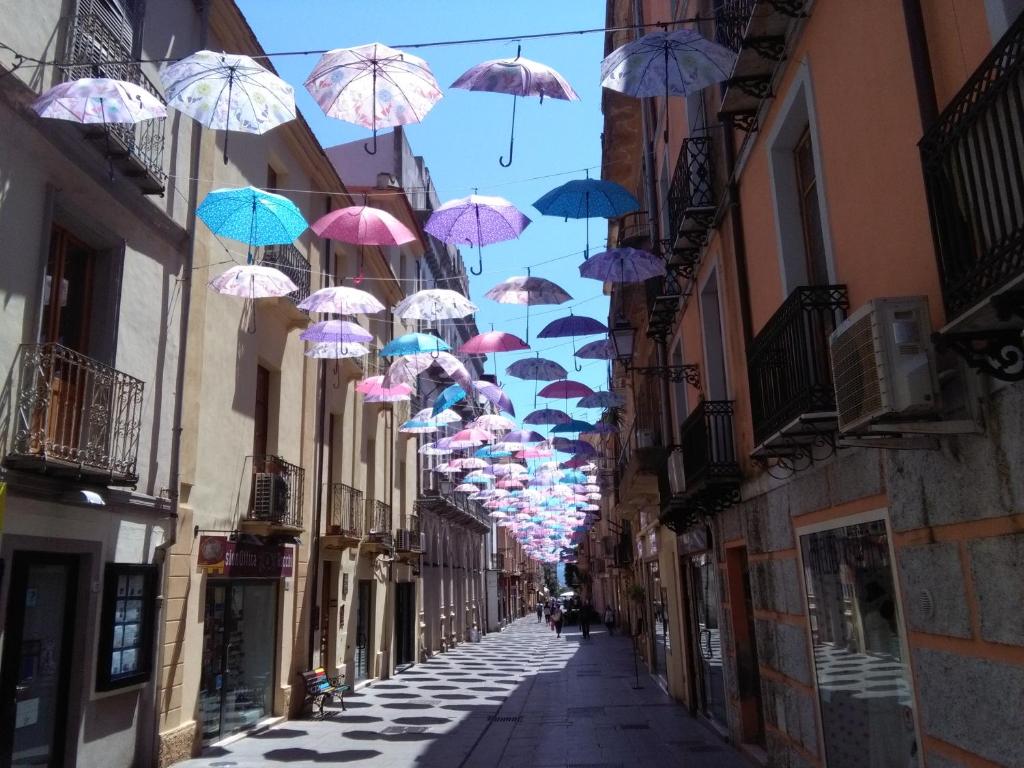 un montón de sombrillas colgando sobre una calle en b&b del corso, en Iglesias