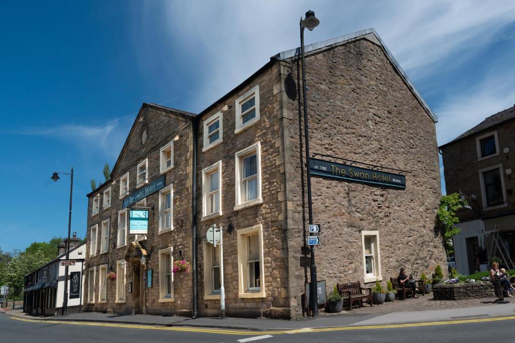 um velho edifício de pedra na esquina de uma rua em The Swan Hotel em Clitheroe