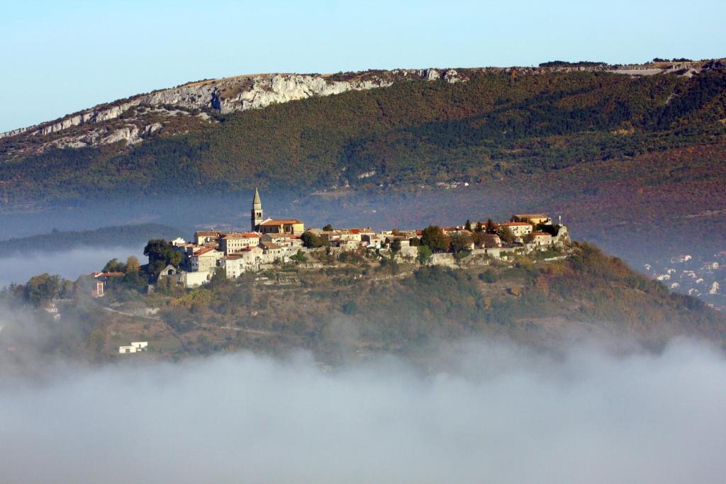 un castillo en la cima de una colina sobre las nubes en Apartment Bastion, en Buzet