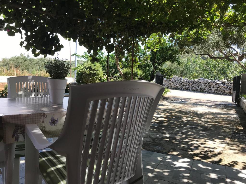 uma mesa com duas cadeiras brancas e uma mesa com uma árvore em Apartman Mirjana em Okrug Donji