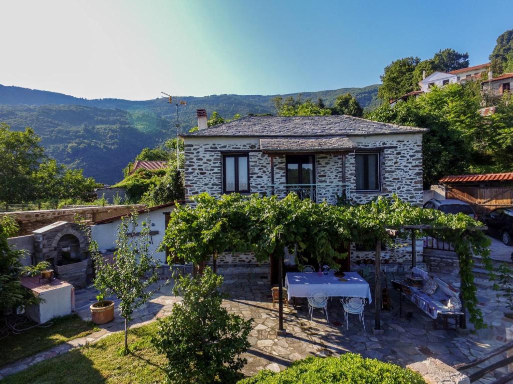 une petite maison en pierre avec une table et des arbres dans l'établissement Filoxenia- Drakia, à Drakeia