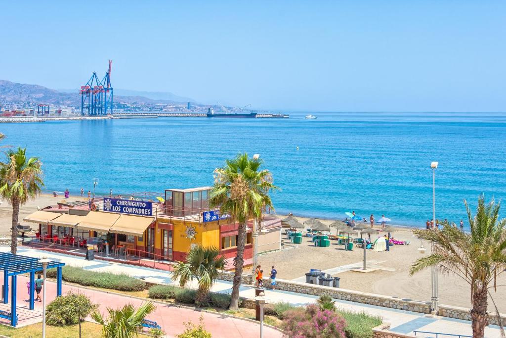 vistas a una playa con palmeras y a un edificio en iloftmalaga Pacífico 15, en Málaga