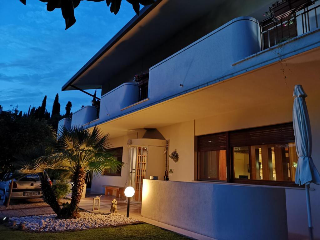 una casa azul con una palmera delante de ella en B&B Villa Bianca, en Sona