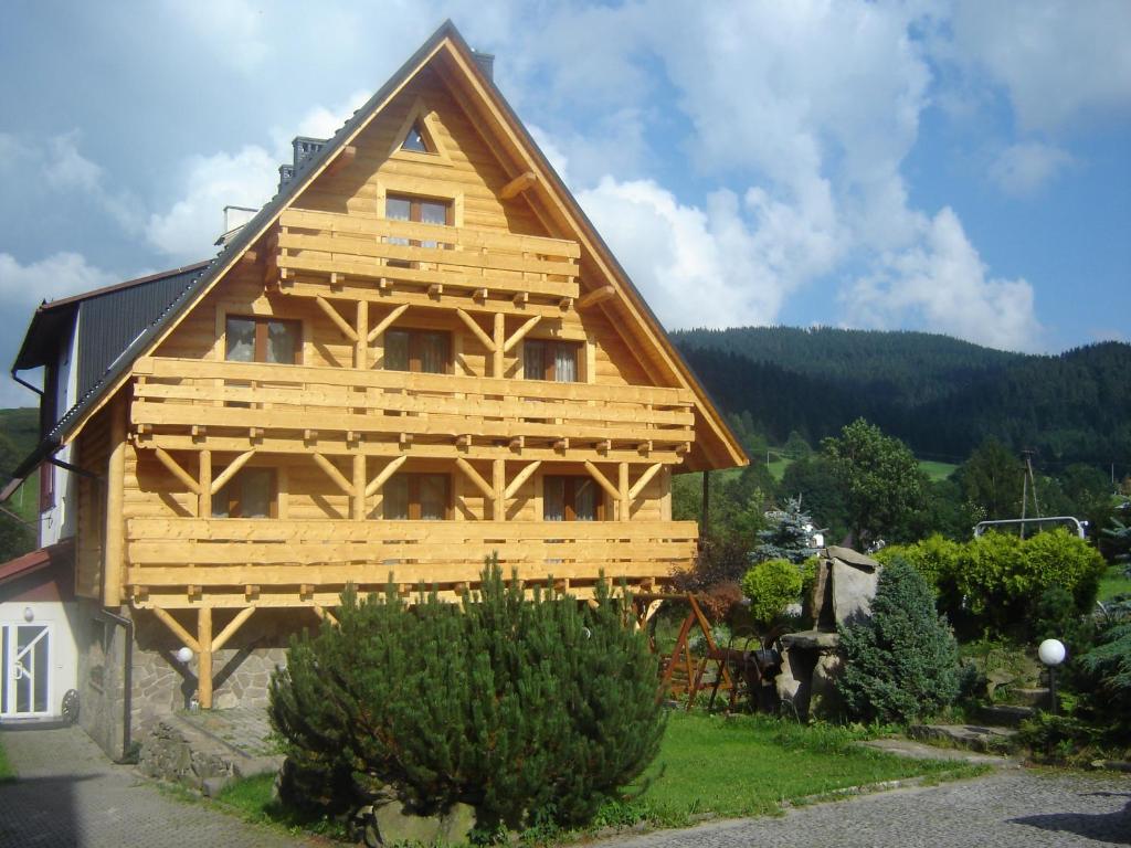 una casa de madera con techo de gambrel en Ośrodek Wczasowy Wierchy, en Korbielów