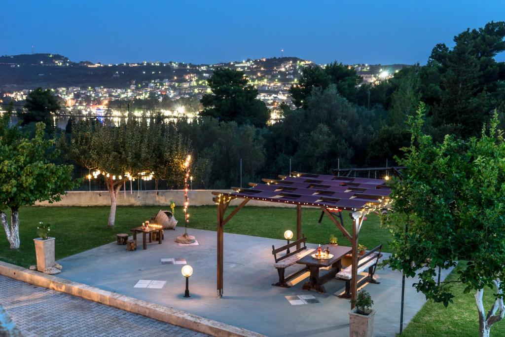 un gruppo di tavoli e panche in un giardino di notte di Acqui Villa ad Argostoli
